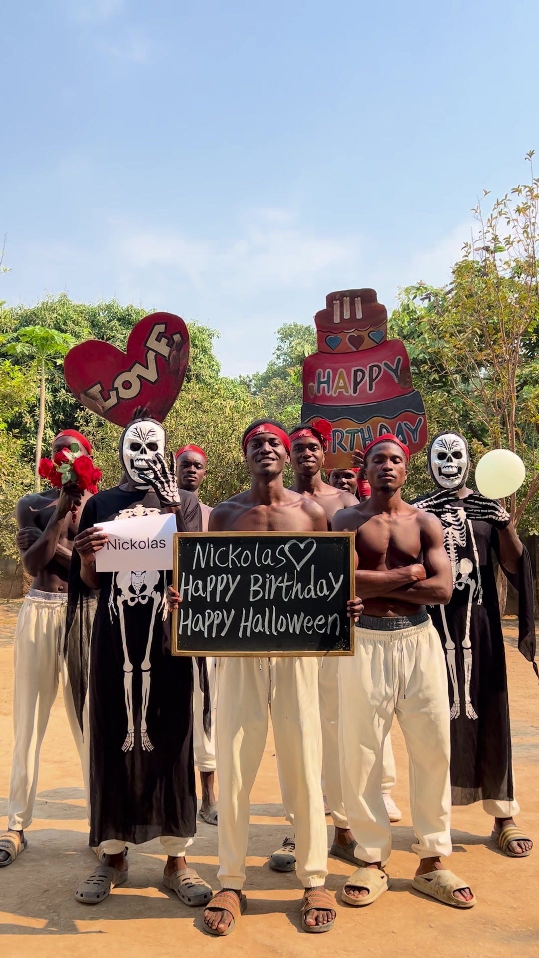 AfriCelebrate dancers in skeleton Halloween costumes holding a personalised Happy Birthday Happy Halloween board